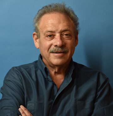 Man smiling with arms crossed, blue background. Man smiling with arms crossed, blue background.